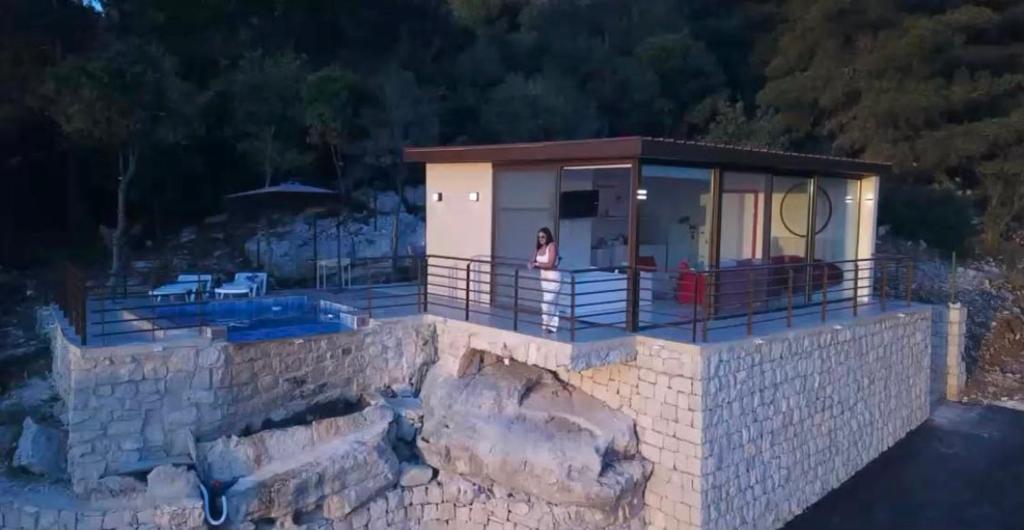 una donna in piedi sul balcone di una casa di Amaruna LB a Al Qarşā