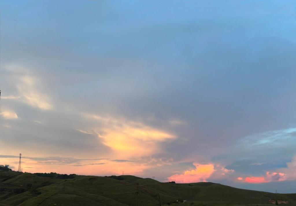 a cloudy sky over a hill with a sunset at Cloud Valley Inn in Cherrapunji