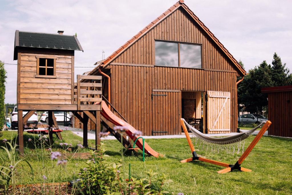 a house with a hammock in front of it at Stodoła Baryczy in Postolin