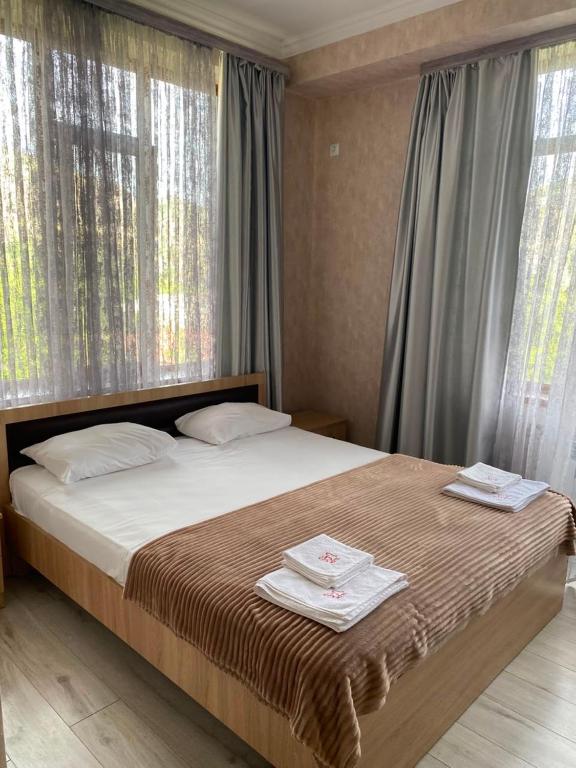 ein Schlafzimmer mit einem Bett, auf dem zwei Handtücher liegen in der Unterkunft Tegh Hotel in Goris