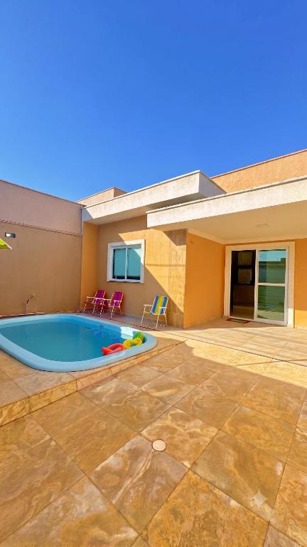 a swimming pool in the backyard of a house at CASA MARIANNA em Paracuru - Piscina, 3 quartos, ar condicionado e perto de tudo! in Paracuru