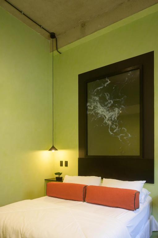 a bedroom with a bed and a painting on the wall at Chilltepe Boutique Apartments - Flores Island in Flores