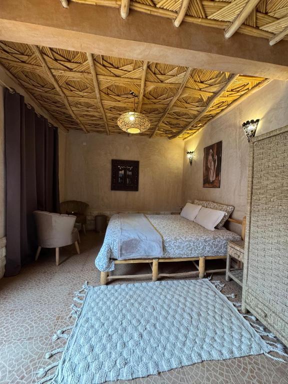 a bedroom with a bed and a wooden ceiling at Guest House Bagdad Café in Aït Benhaddou