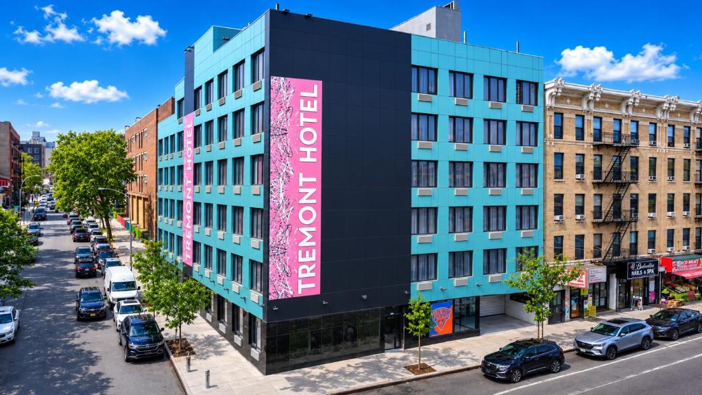 a building with a large sign on the side of it at TREMONT HOTEL BRONx-GRAND OPENING in Bronx