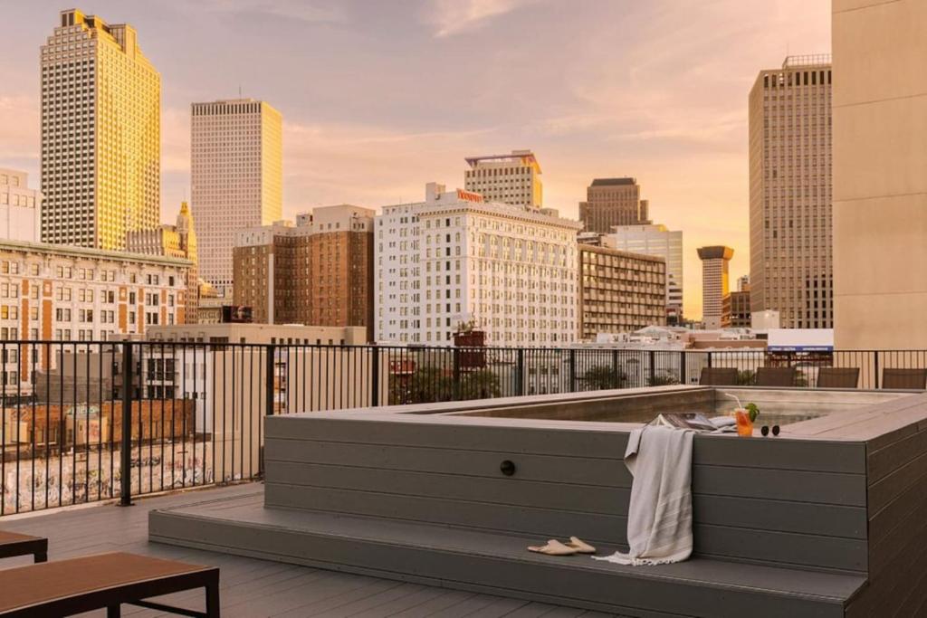 a person sitting on a bench on a rooftop with a city skyline at Schaeffer Hotel in New Orleans