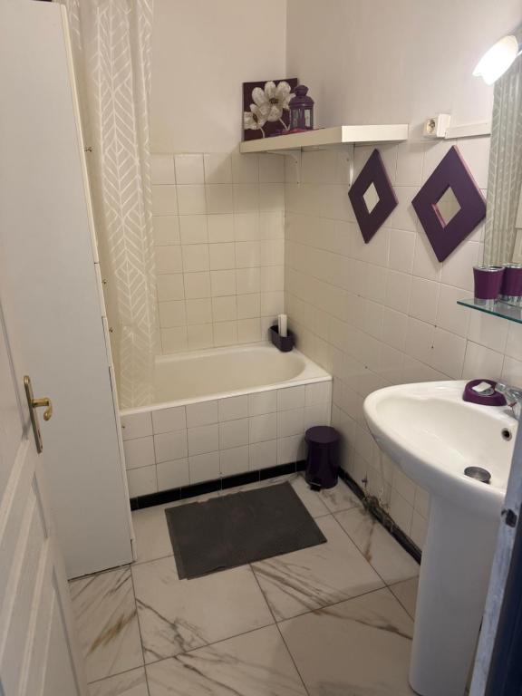 a bathroom with a sink and a tub and a toilet at Chez Séverine in Avignon