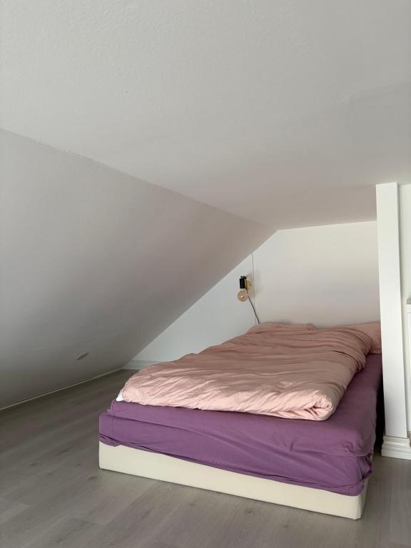 a bed in a white room with a bedvisor at Central apartment for ONS in Stavanger