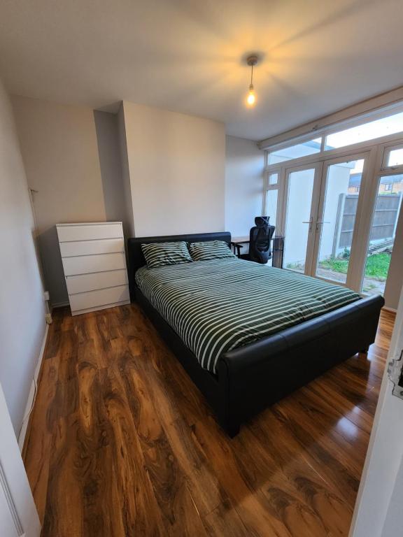 a bedroom with a bed and a wooden floor at The Willow in Aveley