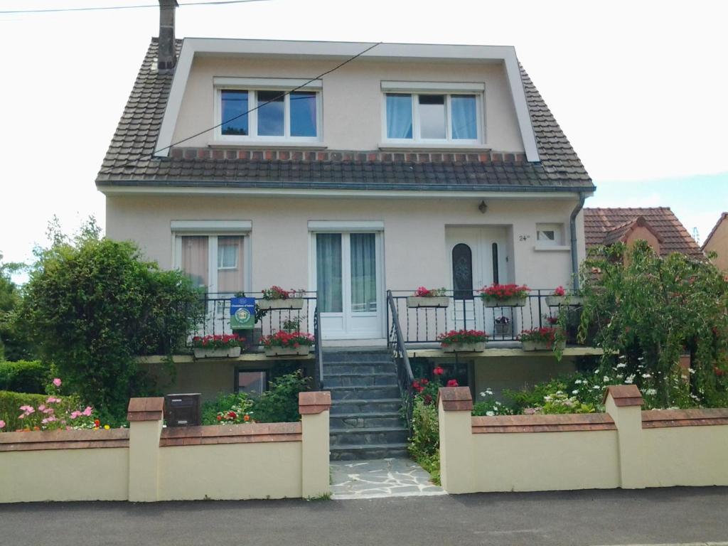 una casa blanca con flores en las escaleras en Chambres d’hotes vue sur la Campagne en Marquise