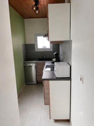 a small kitchen with a sink and a refrigerator at Maison in Reignac
