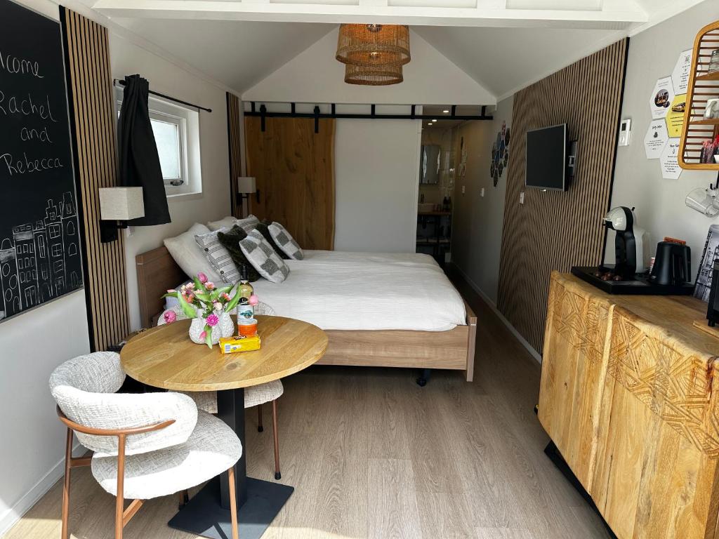 a small room with a bed and a table at Style Gardenhouse Zwanenburg near AMSTERDAM, HAARLEM, ZANDVOORT in Zwanenburg