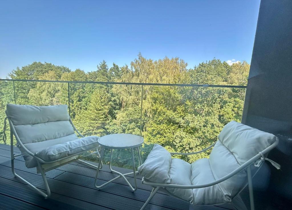 two chairs and a table on a balcony with a view at Apartmán podlesí in Havířov