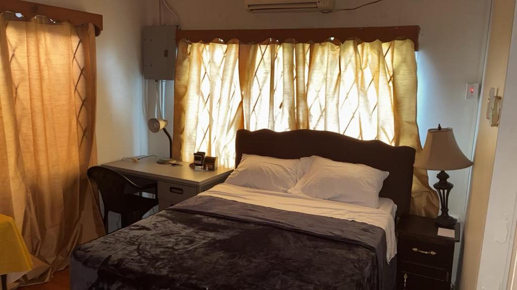 a bedroom with a bed with a desk and a window at The Doctor's Quarters DQ in San Fernando