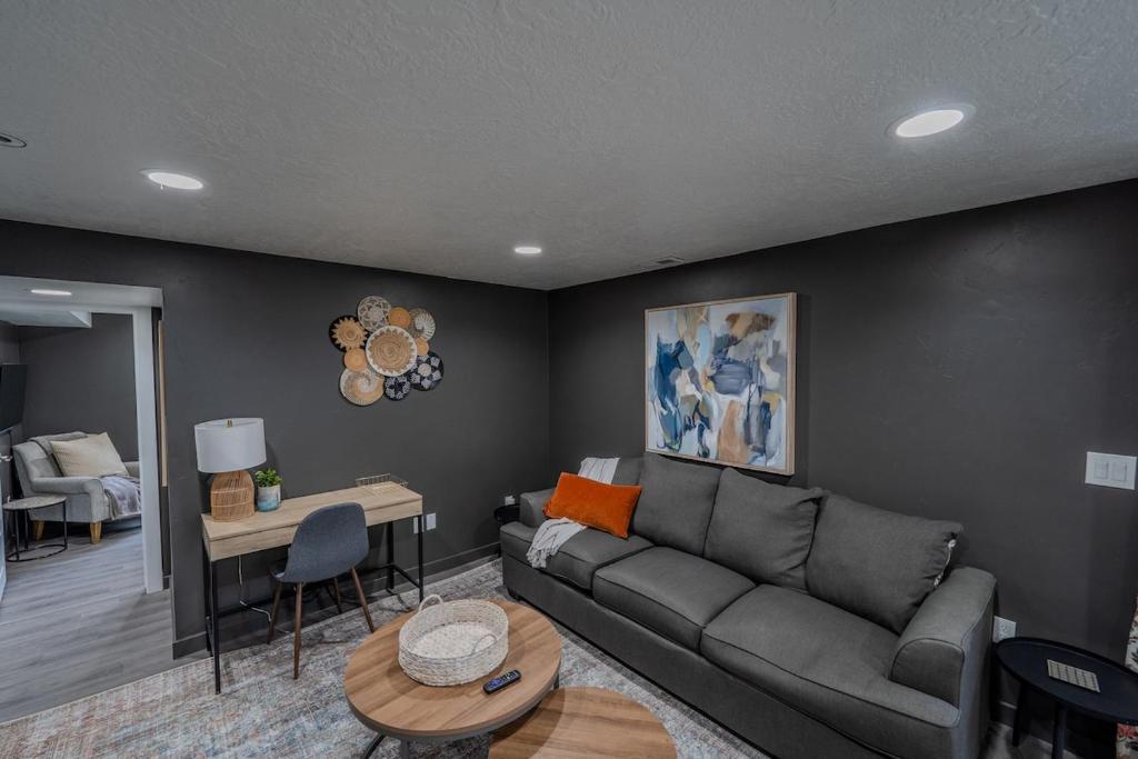 a living room with a couch and a table at Modern Basement Apartment King Bed and Full Kitchen in Bluffdale