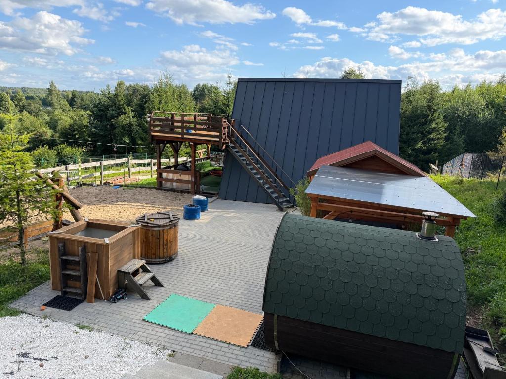 a backyard with a wooden table and a building at Domek letniskowy Jemiołowo in Olsztynek