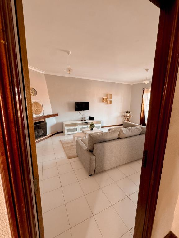 a living room with a couch and a tv at Titi's House in Gulpilhares