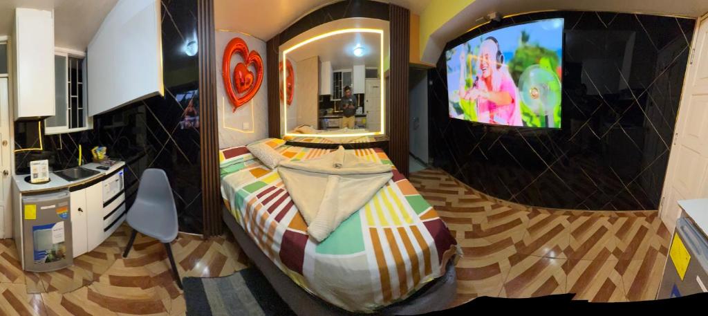 a bedroom with a bed and a tv in it at Gold House Premium in Quito