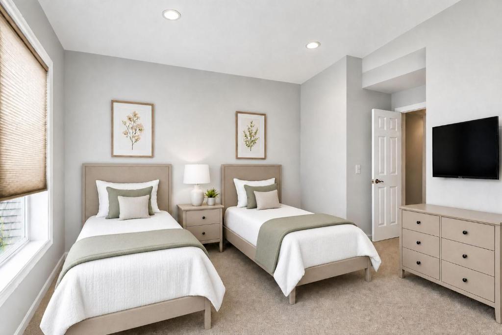 two beds in a room with a tv and a bedroom at PINE AND TIMBER GETAWAY in Jackson