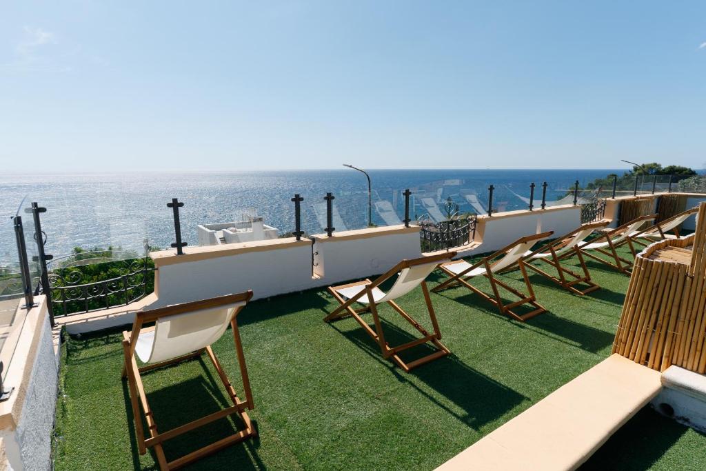 a row of chairs sitting on a balcony overlooking the ocean at Villa Nicole Vista Mare in Andrano