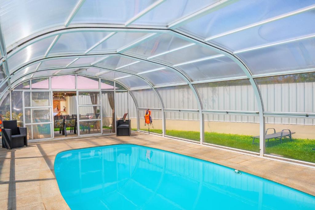 a swimming pool with a metal roof over it at Casa do Lago guest house in Espinho