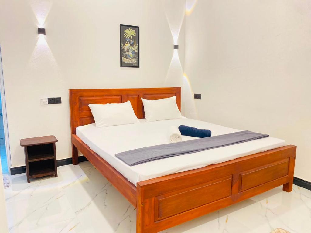 a bedroom with a wooden bed in a room at The Royal Ember in Arugam Bay