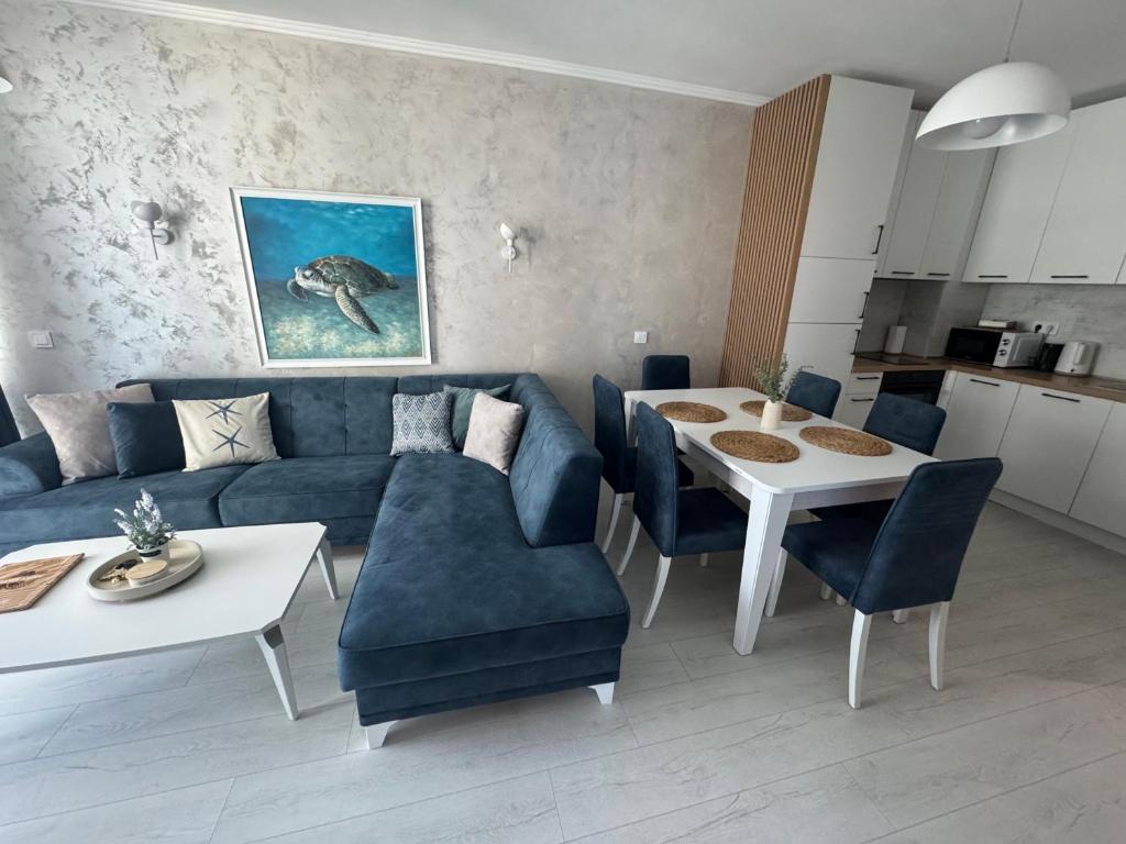 a living room with a blue couch and a table at Turtle Apartment Sunny Beach in Sunny Beach