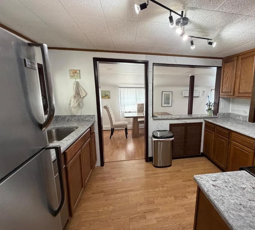 a kitchen with a stainless steel refrigerator and a dining room at Floral Canal-Facing Hideaway in Chesapeake City