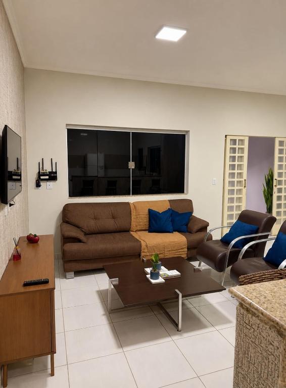 a living room with a couch and a table at Casa Completa próxima ao Centro in Passos
