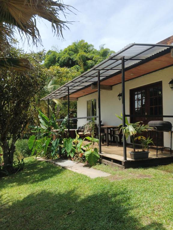 a house with a porch with a table and plants at Cabaña con Jacuzzi Privado en El Peñol El palmar lodge in Chiquinquirá