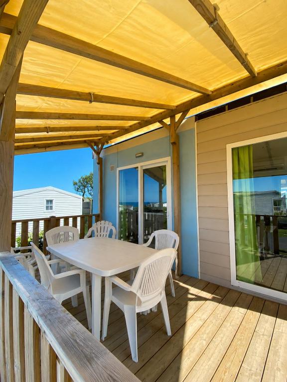 a patio with a table and chairs on a deck at Blueportel Prestige in Le Portel