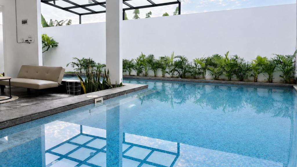 a pool in a building with a chair and a table at Altura Esthetic Villas in Bokor
