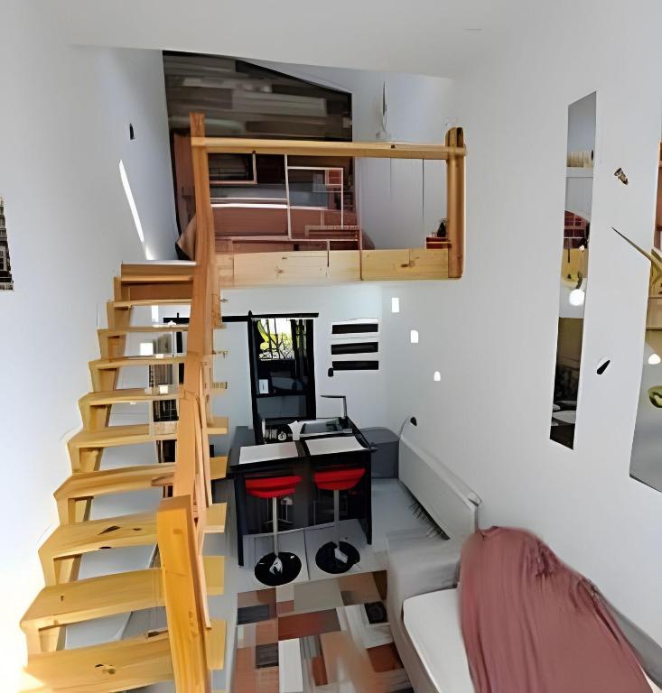 a small apartment with a staircase and a desk and stool at 4 Rest in a warm and comfortable loft in Coihaique