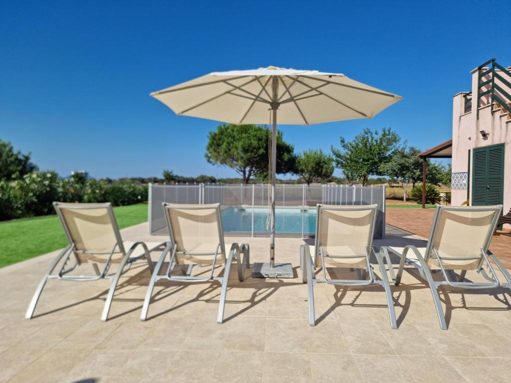 a table and chairs and an umbrella on a patio at Petit Son Bauló in Can Picafort