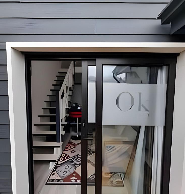 a glass door with the letter o on it next to a staircase at Comfort, Innovation, Style, WiFi, Gym in Coihaique