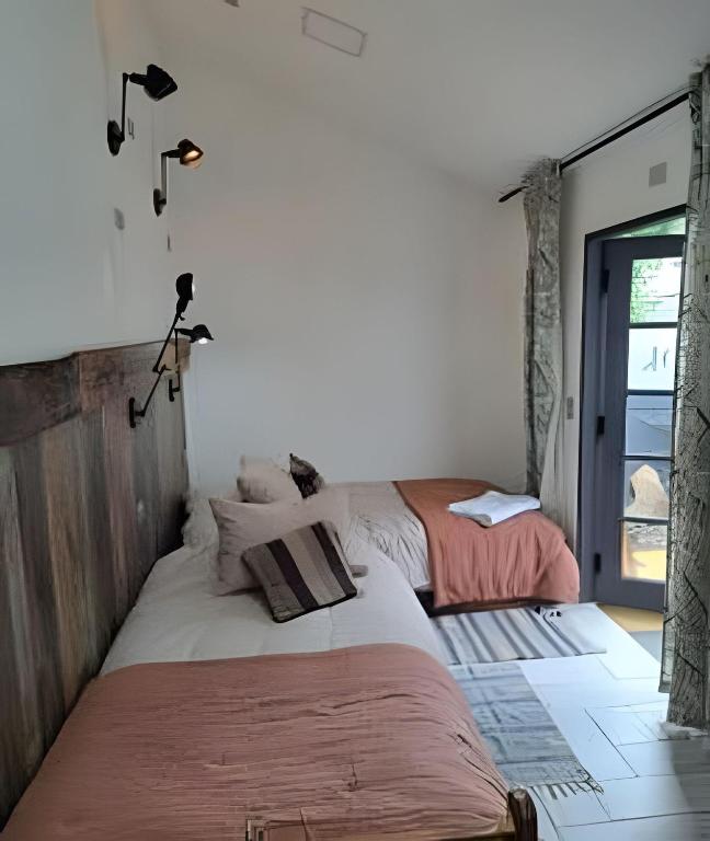 a bedroom with two beds and a window at 6 Universal Access Comfort WiFi central heating in Coihaique