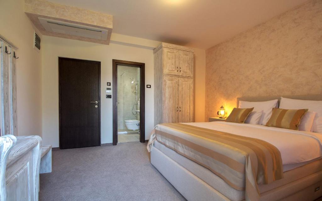a bedroom with a large bed and a bathroom at Hotel Helada in Tivat