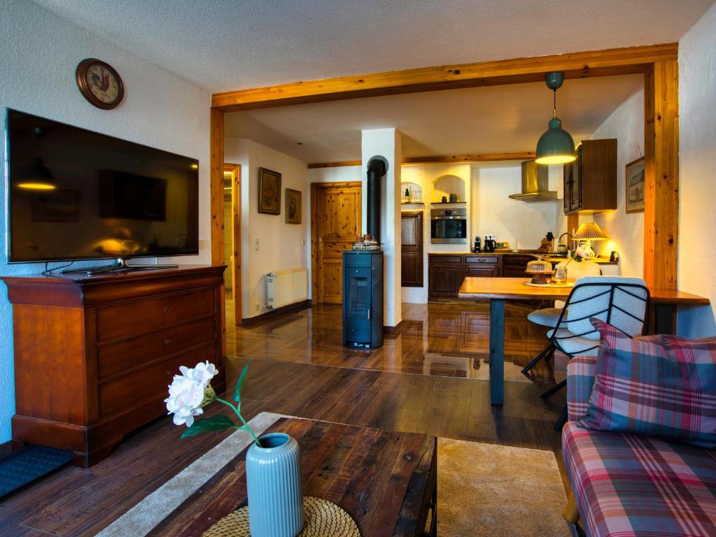a living room with a couch a table and a kitchen at Ferienwohnung Cozy Cottage in Morbach