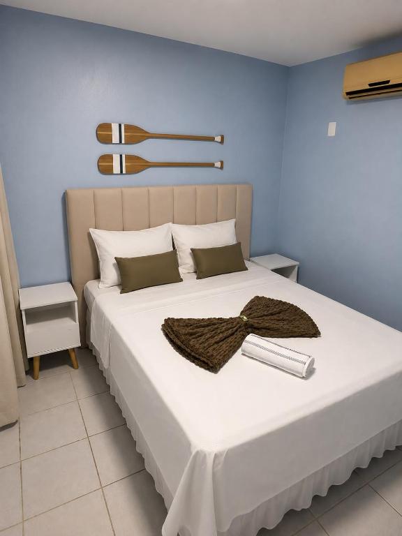 a bedroom with a large white bed with a bow on it at Pousada Ocean Mare in Praia do Frances