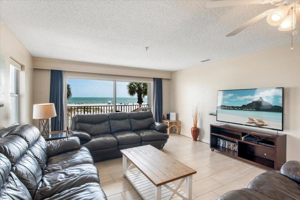a living room with a couch and a tv at Sea Breeze 101 Beach Bliss in St. Pete Beach