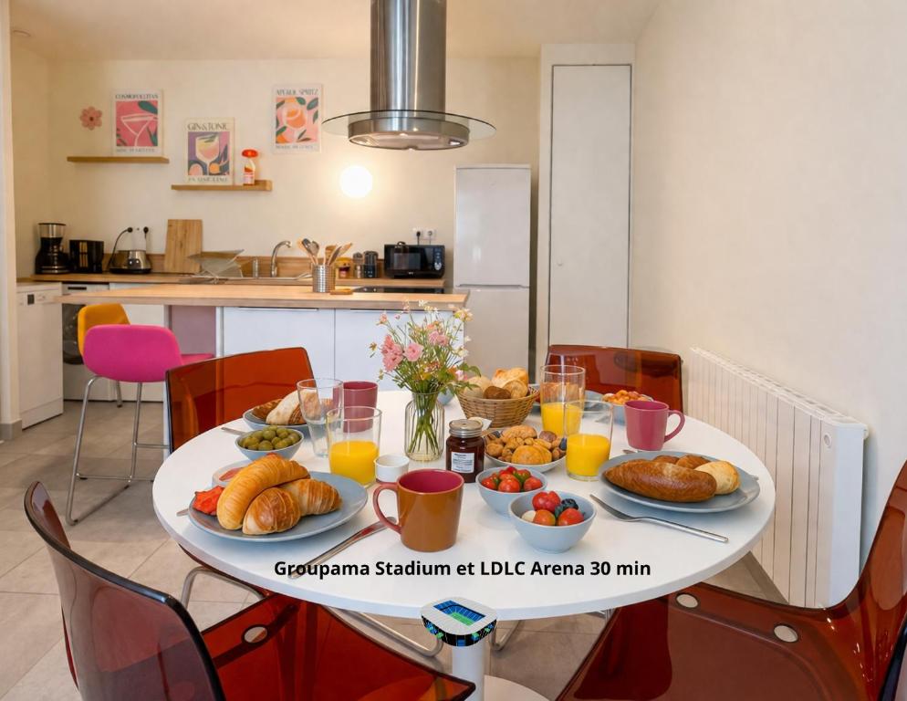 a table with plates of bread and orange juice at Lyon funky flat piscine et parking in Tassin-la-Demi-Lune