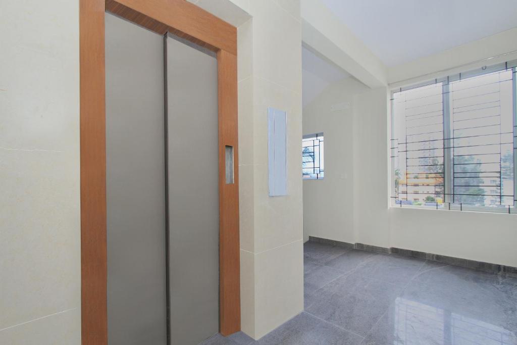 an empty room with a door and a window at Hotel O Manu Residency in Bangalore