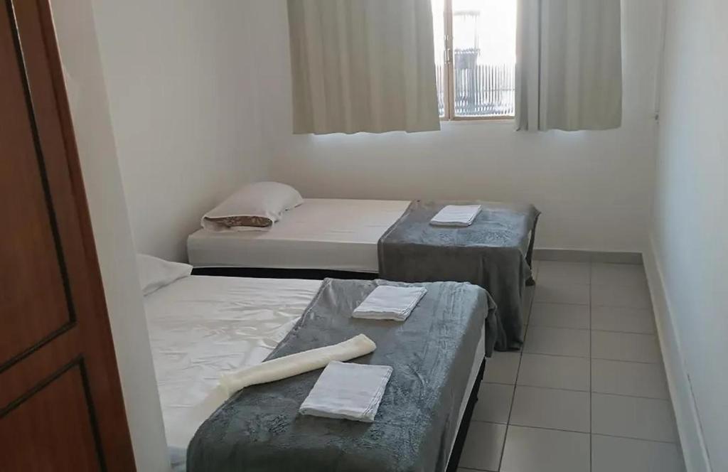 two beds in a room with towels on them at Pousada Central Itabirito in Itabirito