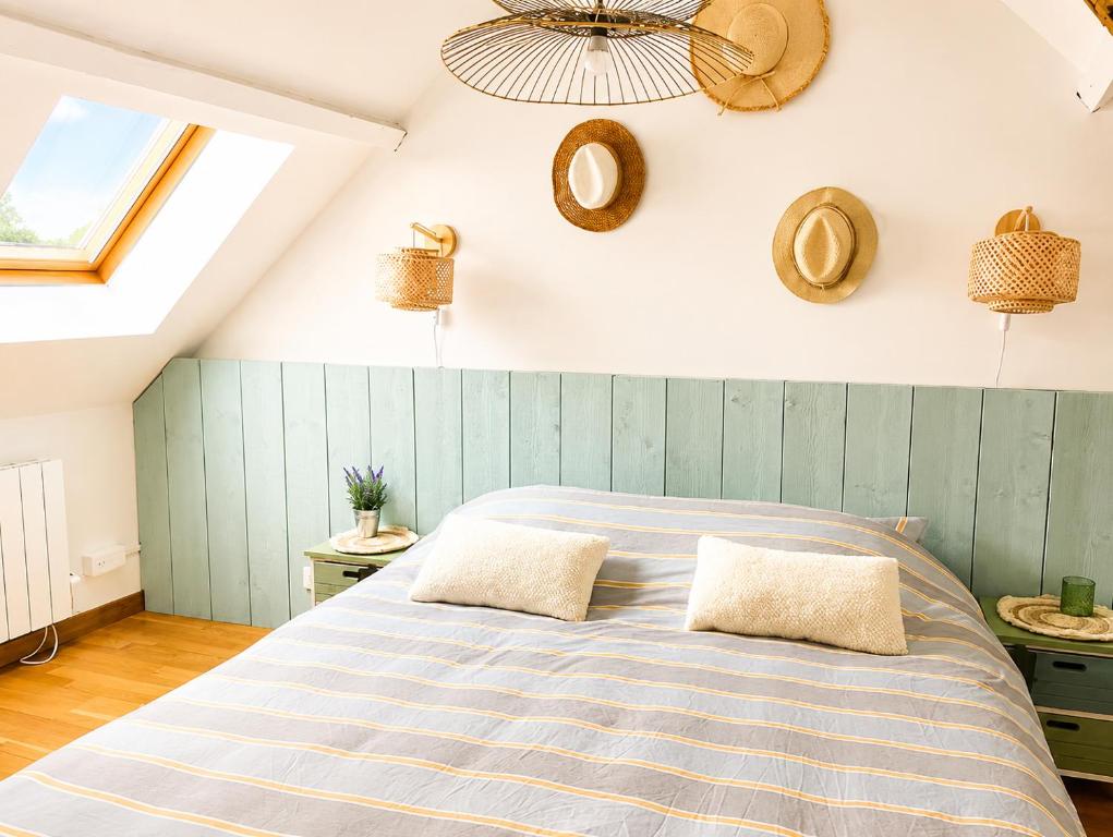a bedroom with a bed with two pillows on it at maison cosy centre ville in Ham