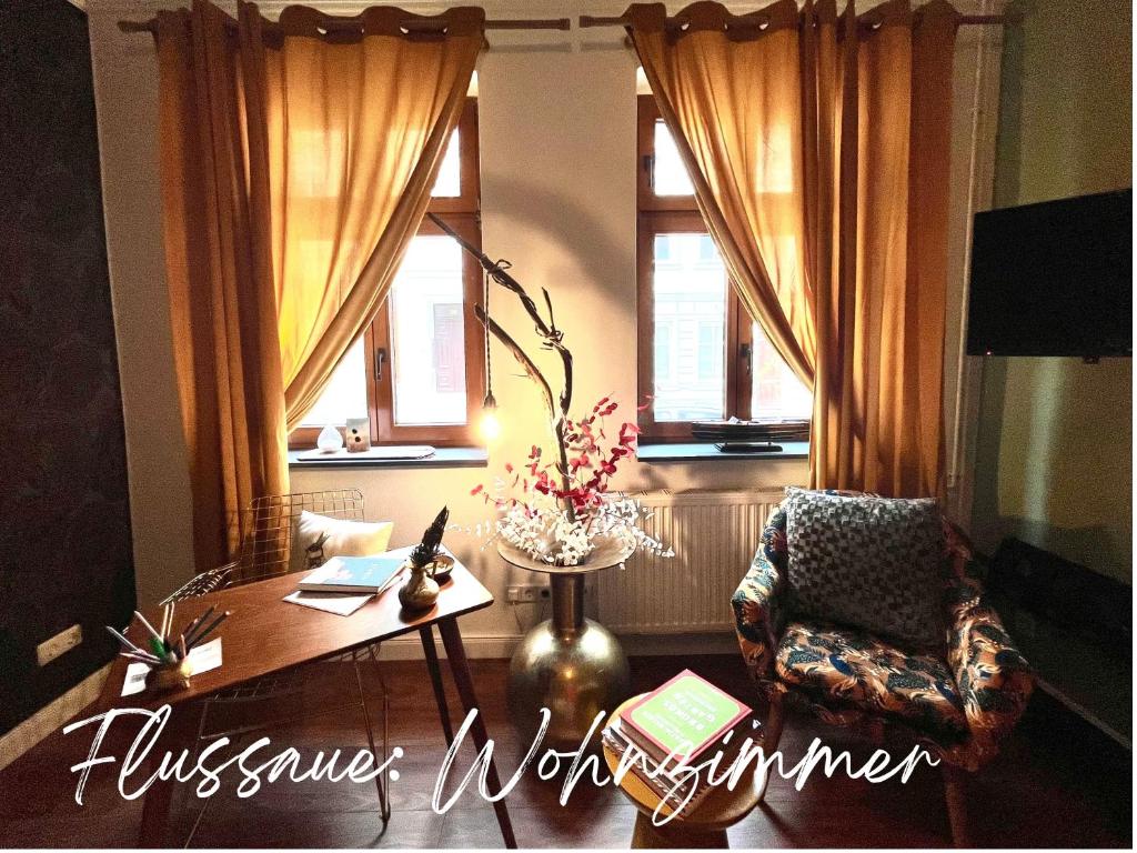 a living room with a chair and a table and windows at Havelzeit in Havelberg