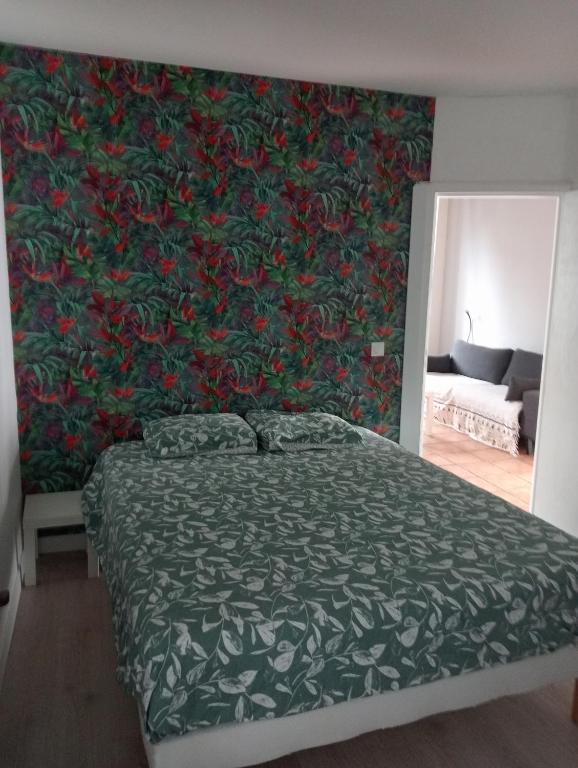 a bedroom with a bed with a green and red wall at Maison Belzaenea in Espelette