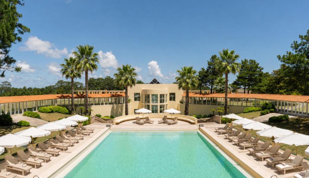 a swimming pool with lounge chairs and a resort at Locanda Punta Del Este in Punta del Este
