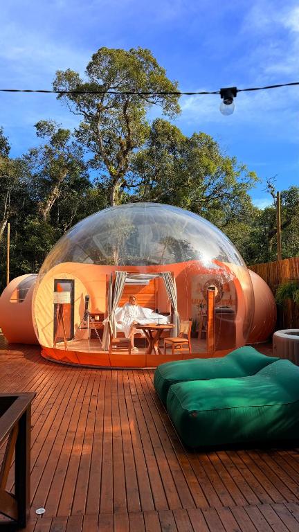 a glass dome on a deck with a bed in it at Sora Bubble in Angelina
