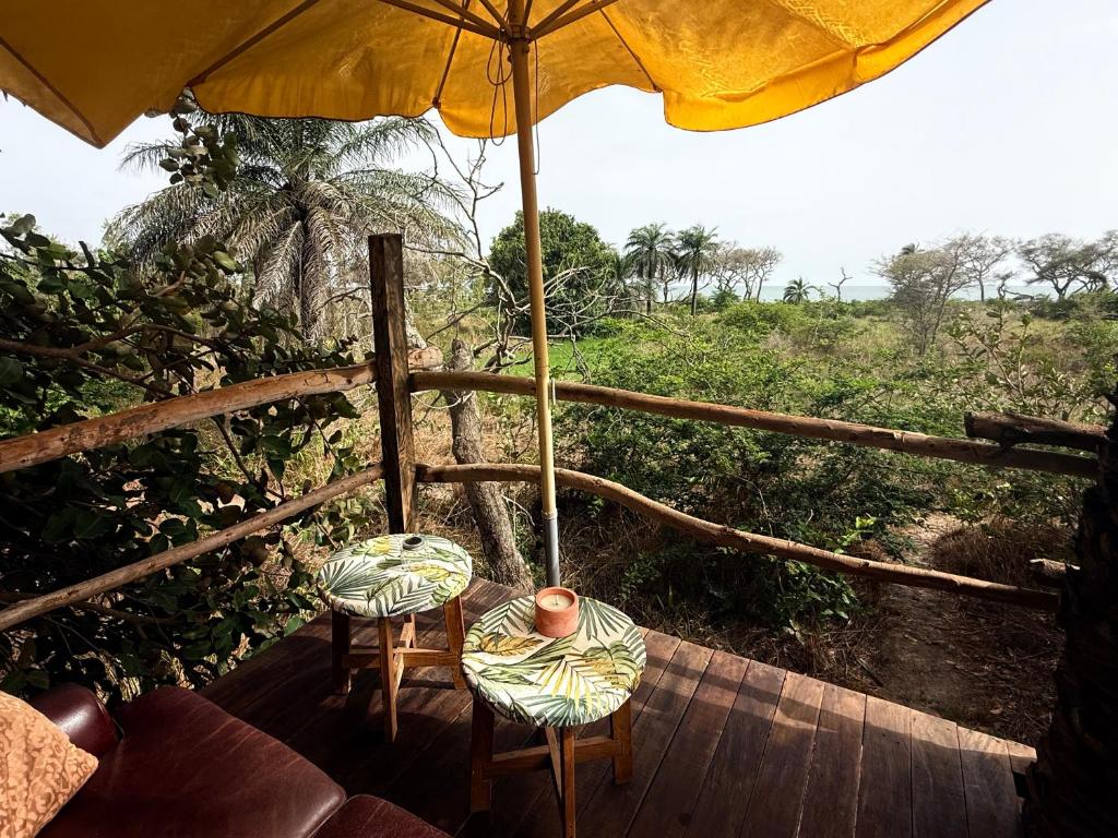 an umbrella and two chairs on a wooden deck at Mansa Musso Lodge in Sanyang