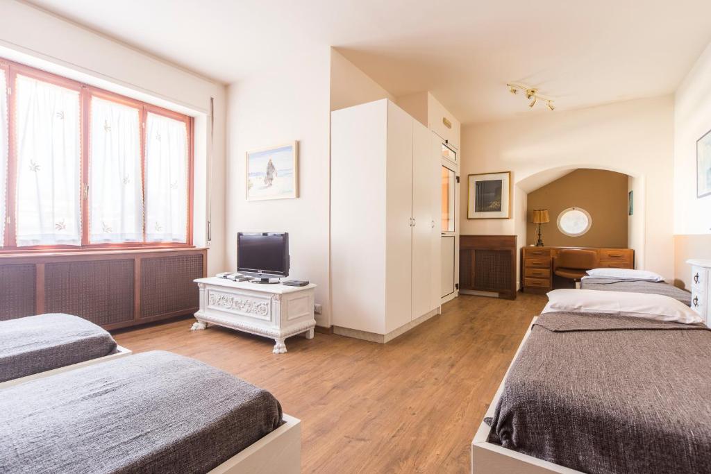 une chambre avec deux lits et une télévision dans l'établissement Villa Senagra Holidays Lake Como, à Menaggio 39 autres photos