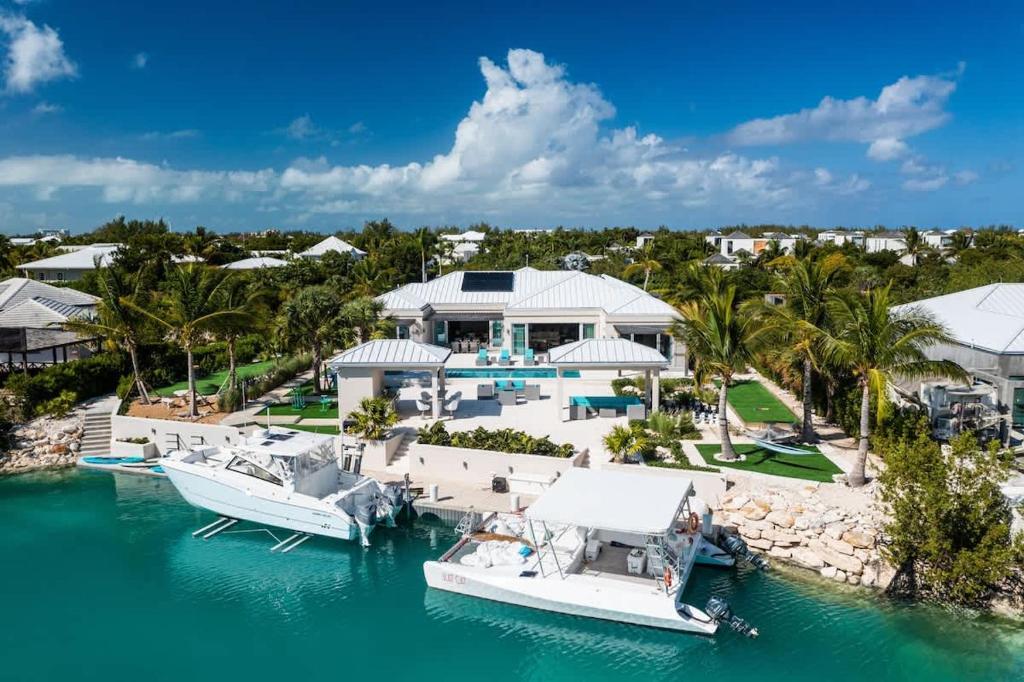 an aerial view of a house with boats in the water at Moringa Villa in Long Bay Hills